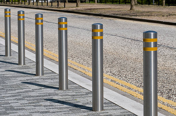 Robust steel bollards protecting a pedestrian walkway.
