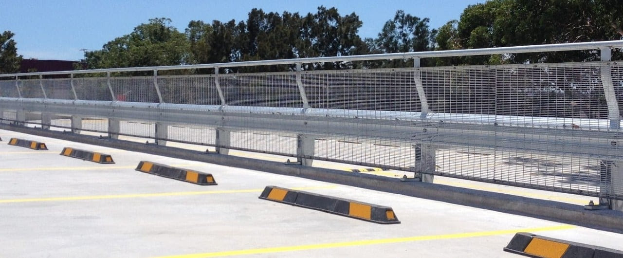 Yellow safety barriers inside a multi-level car park.